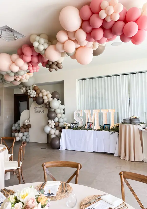 Blush, mocha and ivory balloon garland over a Congratulations backdrop and marquee letters