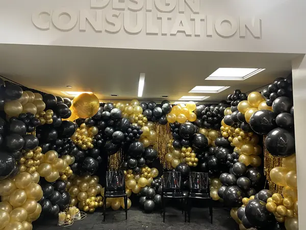 Black and gold balloon wall with gold fringe for a company event
