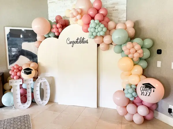 Blush, sage and peach balloon garland around a Congratulations graduation backdrop