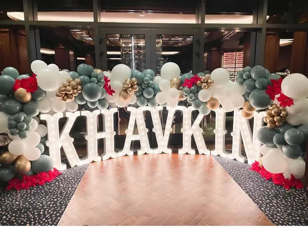 Giant marquee name letters framed by balloons at an event