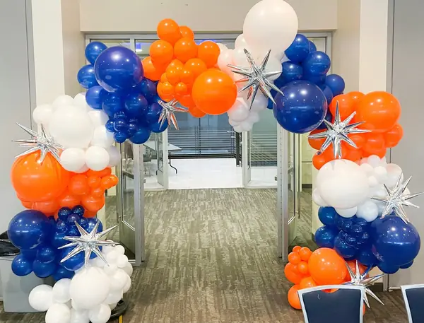 Orange, navy and white balloon arch with silver starbursts