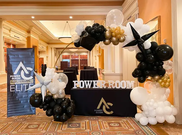 Black, gold and white balloon arch for a business event in a hotel foyer