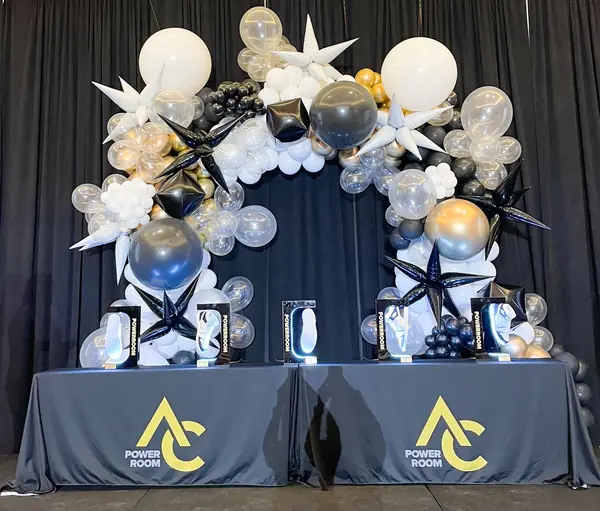 Black, white and silver starburst balloon arch over a conference stage