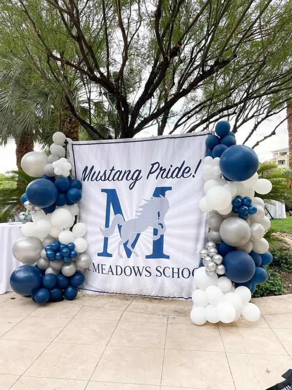 Navy, silver and white balloons framing a school spirit banner