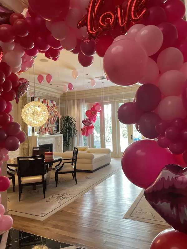 Red and pink balloon garland with a LOVE balloon in a living room