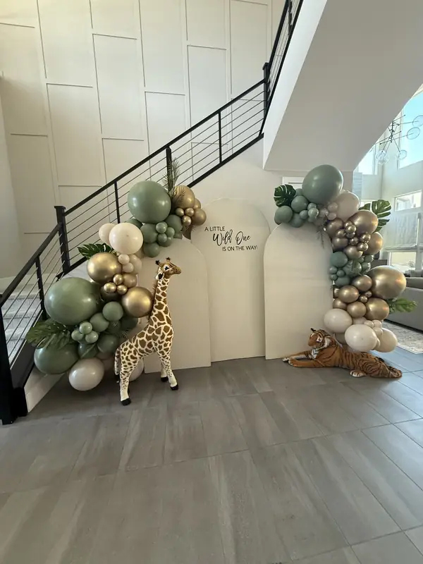 Sage, gold and ivory balloon garland around a safari baby shower backdrop